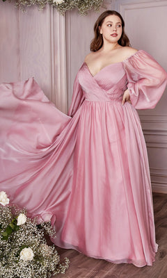 A woman models the Ladivine Plus-Size Off-Shoulder Prom Dress CD243C in pink, standing indoors beside light wood-paneled walls and a floral arrangement of white roses and baby's breath.