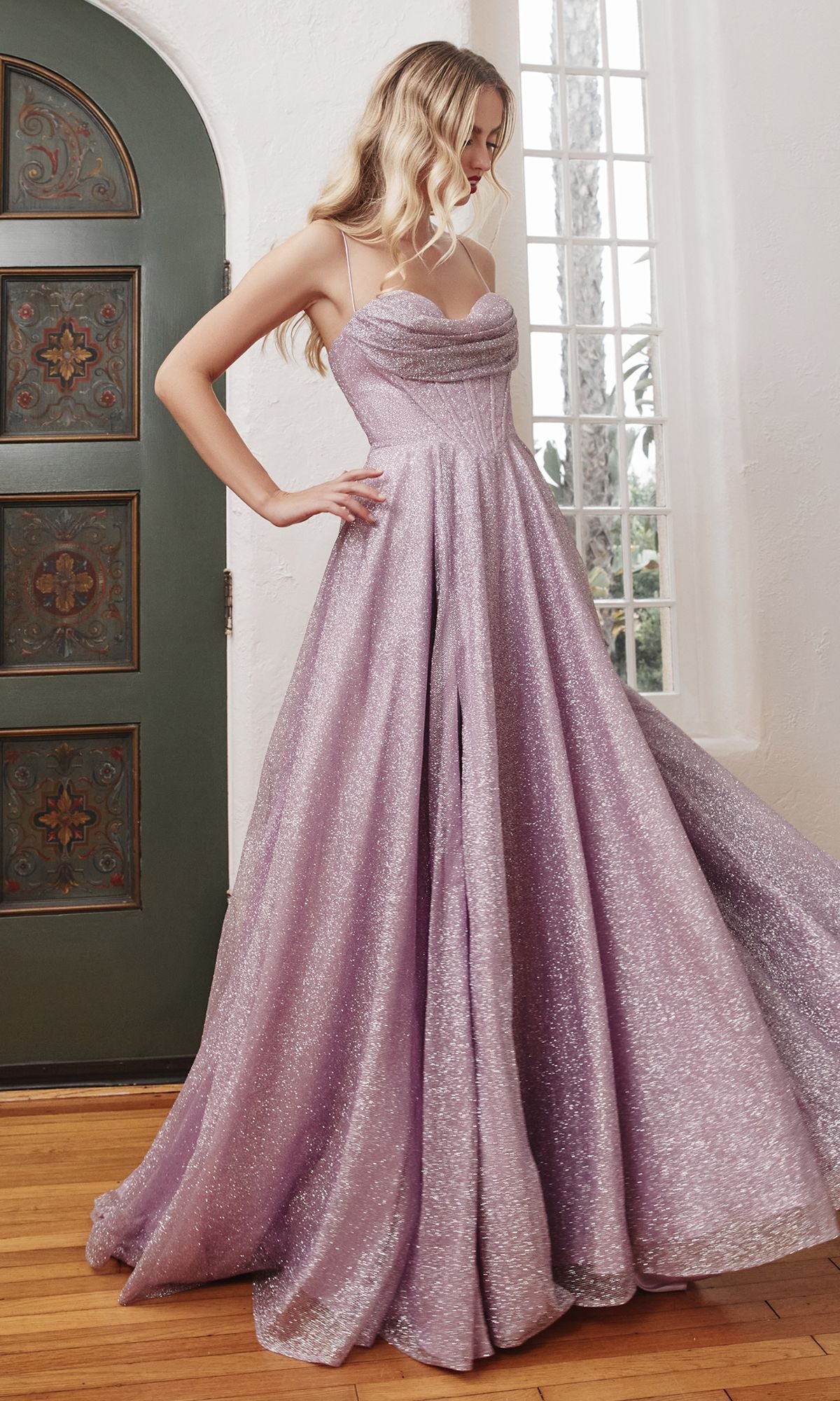 A woman in the Draped-Bodice Long Glitter A-Line Prom Dress CD252 with thin straps stands indoors by a decorative door and large window.