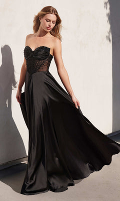 A woman stands against a light-colored wall wearing the Ladivine CD297, a strapless long A-line prom dress with a fitted beaded bodice and flowing skirt.