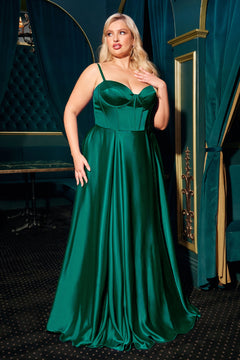 A woman poses gracefully indoors on a dark carpet, wearing the Ladivine CD337C plus-size long A-line emerald green prom dress with thin straps.