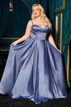 A woman in a shiny, floor-length Ladivine CD337C plus-size long A-line prom dress with a fitted bodice and thin straps holds out her gown in an elegant room with green and gold decor.