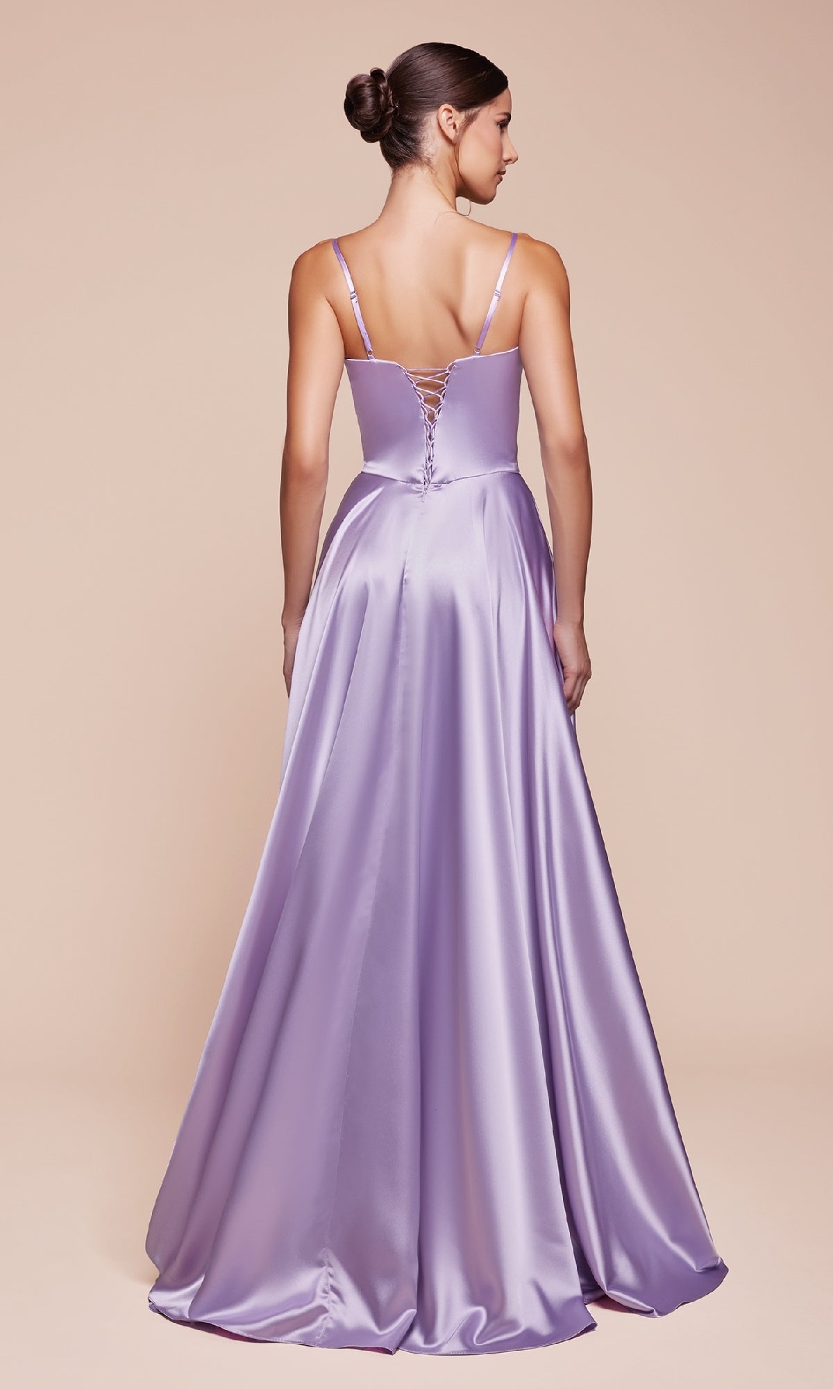 A woman wears the Ladivine CD337 Long Sweetheart A-Line Prom Dress— a floor-length, lavender satin gown with spaghetti straps, lace-up back, and elegant corset bodice — posed against a plain beige background.