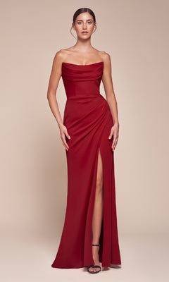A woman wears the Lace-Up Strapless Long Prom Gown: Ladivine CD355 in vibrant red, with a draped bodice and high slit, standing against a plain beige background.