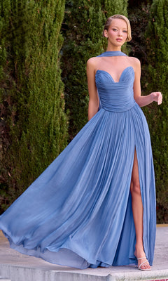 A woman wearing the Ladivine CD410 long prom dress in periwinkle, featuring a strapless sweetheart neckline, thigh-high slit, and flowing a-line skirt, stands outdoors near tall green bushes.