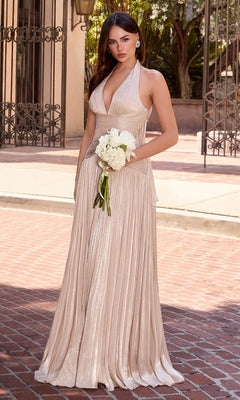 A woman stands on a brick walkway, holding a small white bouquet and wearing the Ladivine CD412 Long Ruched Halter Prom Dress in champagne gold, with buildings and greenery in the background.