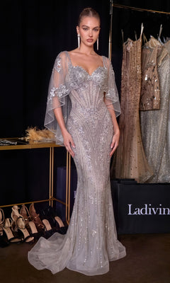 A woman wearing the Ladivine CD637 long prom dress in silver stands beside shelves of high heels and dresses, posing in a fashion showroom.