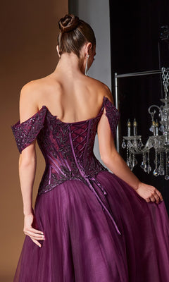 A woman in the Ladivine CD657 long prom dress, featuring an off-the-shoulder deep purple design with a corset bodice, lace-up back, and beaded tulle skirt, stands facing away while holding the embellished gown.