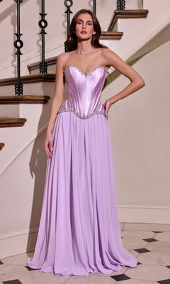 A woman stands indoors on a staircase, wearing the Ladivine CD668 Long Prom Dress in lavender—featuring a strapless, fitted silhouette with a satin corset bodice, metallic waist detailing, and a flowing chiffon A-line skirt.