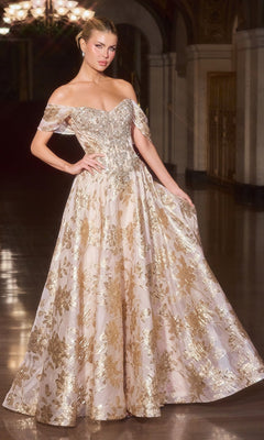 A woman stands in an ornate, dimly lit hall wearing the Ladivine CD682 gold long prom dress, featuring an off-the-shoulder, floor-length silhouette with metallic floral jacquard.