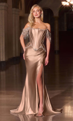 A woman stands in a dimly lit hall wearing the Ladivine CD688 long prom dress in mocha, an off-the-shoulder satin gown with a thigh-high slit, beaded fringe sleeves, and sparkling crystal embellishments.