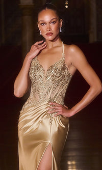 A woman in the Sheer-Corset Long Halter Prom Gown (Ladivine CD690) with an embellished corset-style halter bodice and thigh-high slit poses elegantly indoors, one hand on her hip and the other near her face.