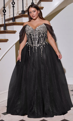 A woman stands on a marble floor near a staircase, wearing the Long Plus-Size Prom Dress Ladivine CD721C in Black/Silver, featuring an off-the-shoulder glitter tulle ball gown with an embellished corset bodice and full skirt.