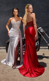 Two women in formal gowns stand by a motorcycle against a dark wall; one wears a beaded silver dress with a thigh-high slit, and the other wears the Side-Drape Strapless Prom Gown: Ladivine CD722 with a dramatic red train.