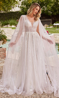 A woman stands outdoors on a gravel path near greenery, wearing the Ladivine CD852W Drape-Sleeve White Formal Dress with sheer cape sleeves and sparkling embellishments.