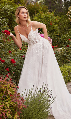 A woman wearing the A-Line White Lace Wedding Gown CD857W with 3D floral lace details stands in a garden, holding a red rose amidst lush greenery and blooming flowers.