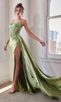 A model wearing a long sweetheart green prom dress with a sheer embellished bodice and a side slit.