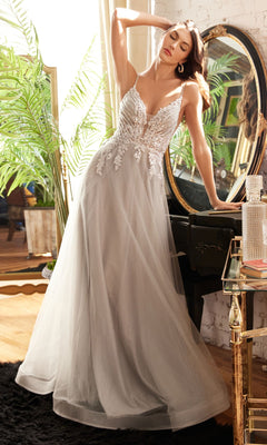 Wearing the Glitter-Bodice Long Prom Ball Gown CD874, a woman stands by a black vanity and round mirror in a bright room decorated with plants and elegant accents.