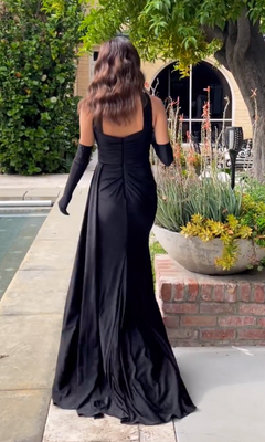 A woman in the Choker Long Prom Dress with Gloves CD886 walks by a pool, surrounded by lush greenery and a large potted plant.