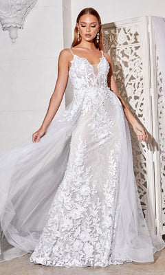 A woman stands indoors near a decorative white screen wearing the Sheer-Corset Long White Lace Wedding Dress CD931W, featuring sleeveless design, floral embroidery, and a flowing sheer overskirt.