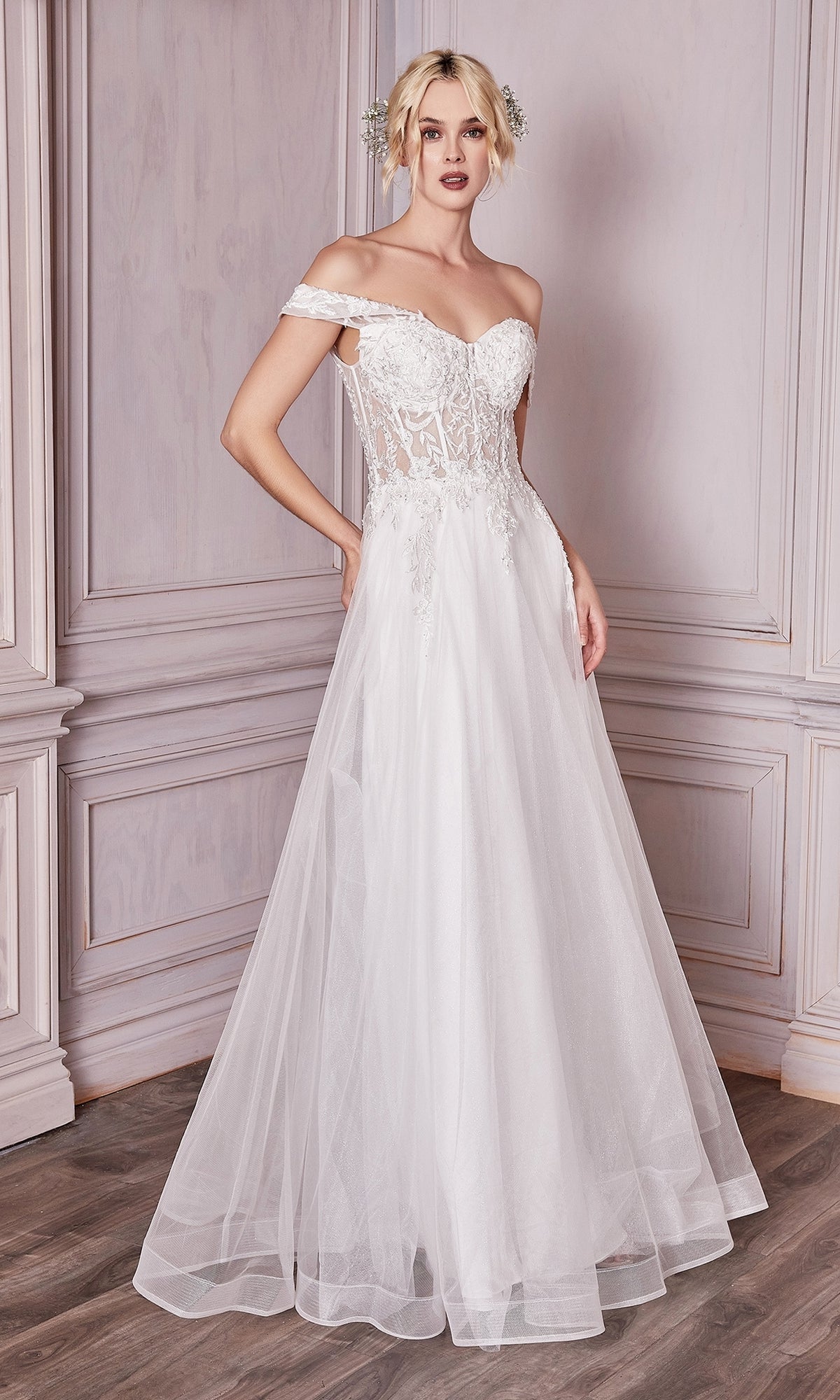 A woman wearing the Sheer-Bodice Long White Prom Ball Gown CD961W stands in a room with light-paneled walls and wooden floors.