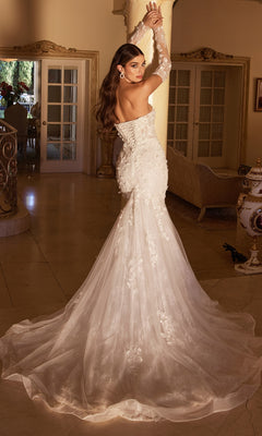 A woman stands indoors, looking over her shoulder, wearing the Long White Strapless Bridal Gown CD977W featuring a mermaid skirt and embroidered floral designs.