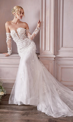 A woman wearing the Long White Strapless Bridal Gown CD977W with a mermaid skirt and long train stands against a light-colored paneled wall.