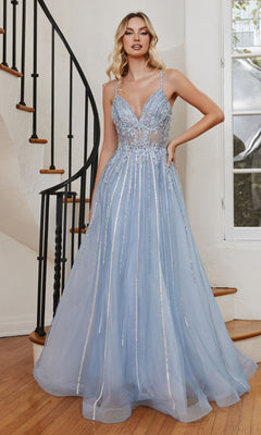 A woman stands on a wooden staircase indoors wearing the Long A-Line Prom Dress with Sheer Bodice CD994—light blue, beaded, featuring a fitted sparkling bodice and spaghetti straps.