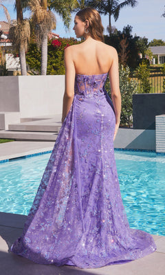 A woman stands by a pool in the Strapless Long Butterfly Prom Dress CD998, a floor-length purple sequin gown with a sheer overlay, facing away from the camera.