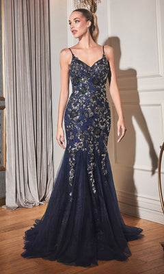A woman stands indoors wearing the Beaded Long Mermaid Formal Dress with Cape CDS438—a navy blue, floor-length mermaid gown featuring sequin floral details and thin straps.