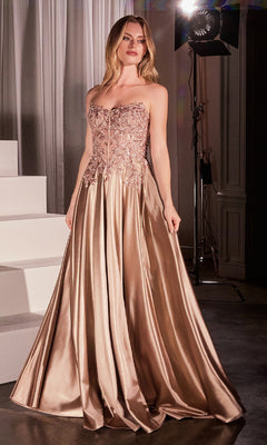 A woman stands indoors wearing the Off-the-Shoulder Prom Ball Gown CDS525—a champagne-colored gown with a beaded bodice and satin skirt, beautifully illuminated by studio lighting.