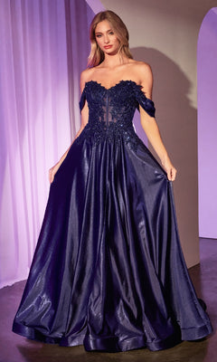 A woman stands wearing the Ladivine CDS525 Off-the-Shoulder Prom Ball Gown, featuring a dark blue hue, floral lace bodice detailing, and a full, shiny skirt.