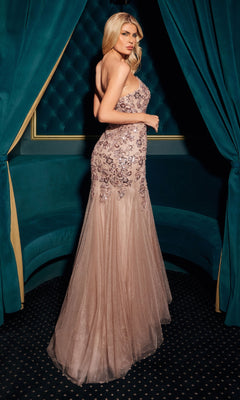 Woman in a strapless, embellished evening gown standing against a decorative backdrop.
