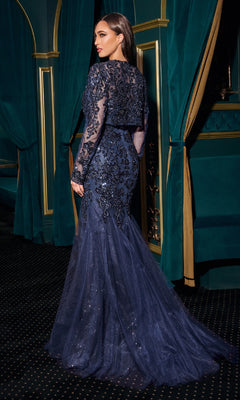 Woman in a dark blue sequined gown standing in an opulent room with green curtains and gold accents.