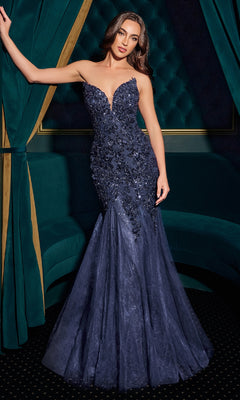 Woman in a navy blue sequin gown standing against a green curtain backdrop
