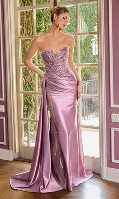 A woman stands by a window in the Ladivine CDS565 long prom dress, a strapless satin gown in dusty lavender with a beaded sheer panel and high slit, its floor-length design shimmering in the light.
