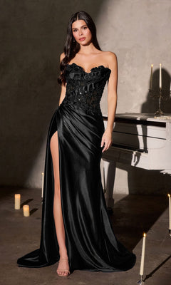 A woman in the Ladivine CDS567 long black prom dress with a 3D floral-beaded strapless bodice, satin skirt, and thigh-high slit stands by a white piano amid glowing candles.