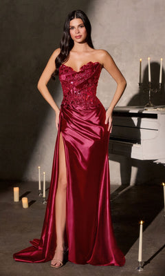 A woman in a deep red Ladivine CDS567 long prom dress with a 3D floral-beaded bodice and satin skirt stands beside a white piano, surrounded by lit candles.