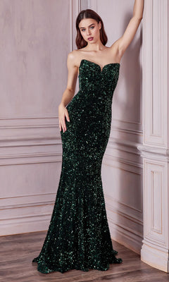 A woman poses indoors in the Sheer-Sides Strapless Long Sequin Prom Dress CH151, a floor-length dark green gown, leaning with one arm raised against a light-colored wall.