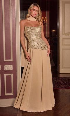 A woman wearing the Ladivine CH2603 long prom dress in gold, featuring a strapless embellished corset bodice and a floor-length A-line chiffon skirt, stands in front of an ornate door in a dimly lit room.