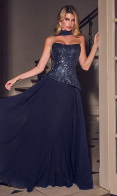 A woman stands indoors wearing the Ladivine CH2603 long prom dress, which features a strapless embellished corset bodice and a flowing chiffon A-line skirt, paired with a matching neck scarf.