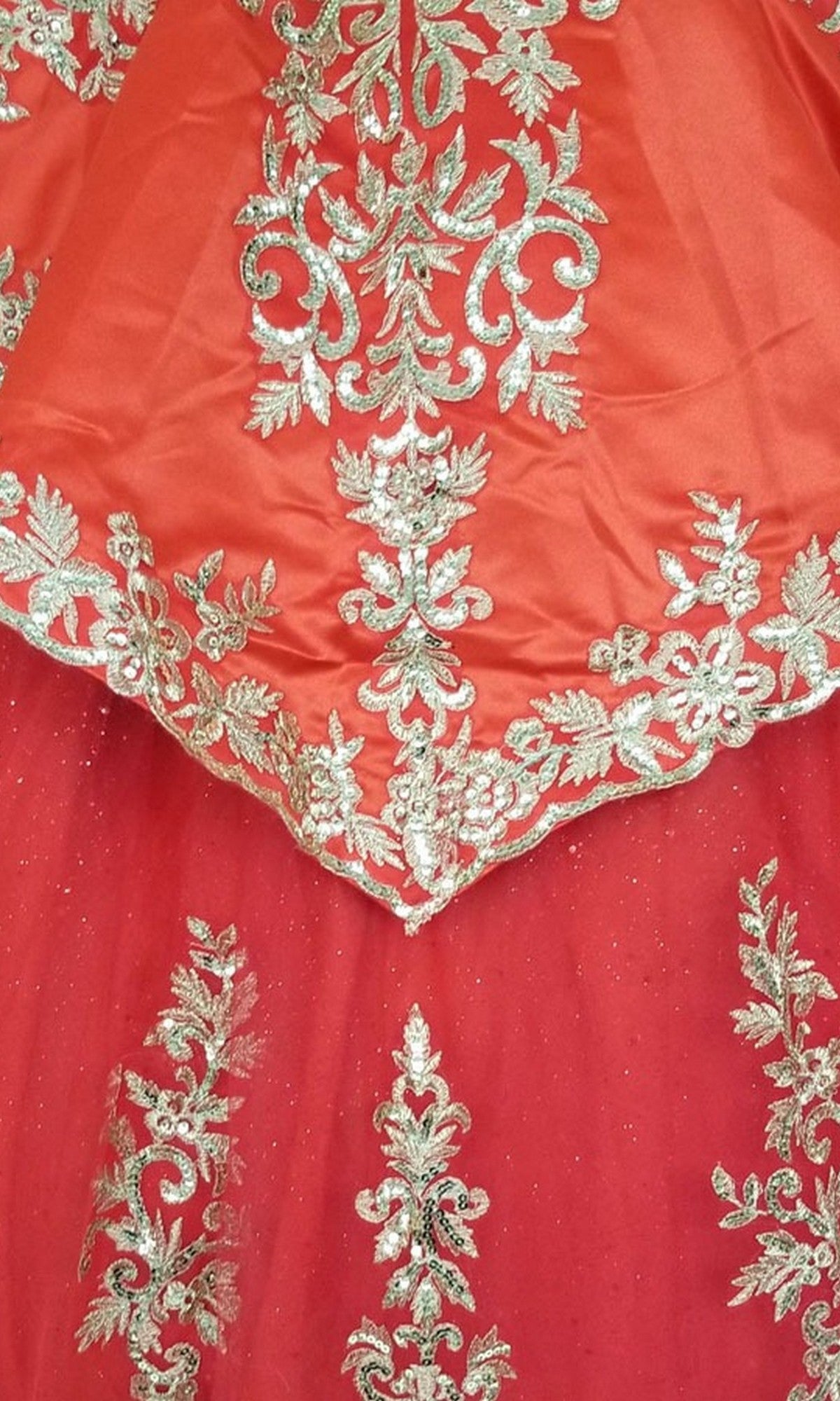 Close-up of ornate, gold floral embroidery on red and orange fabric from the Quinceanera Dress CHF3052 by Chicas.