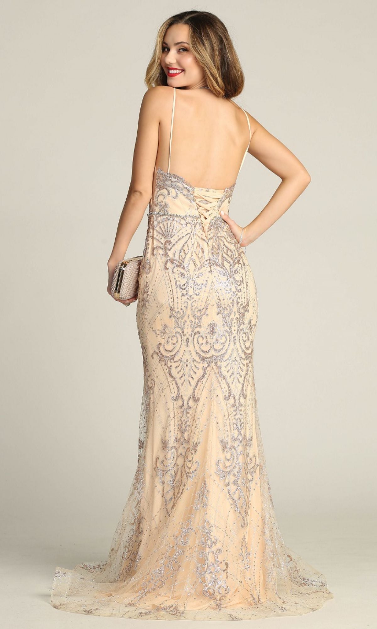 A woman in the Chicas CHF3053 Lace-Up Long Glitter Prom Dress stands against a plain background, holding a small clutch and looking over her shoulder.