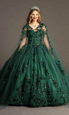 A woman is standing against a plain background and smiling, wearing the Quinceanera Dress CHF3055 By Chicas in green—a dark glitter tulle ballgown with intricate 3D floral appliques and a sheer cape—paired with a silver tiara and necklace.