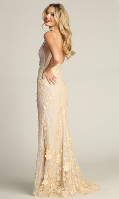 A woman wearing the Chicas CHF3058 Floral-Lace Long Prom Dress, featuring a sleeveless beige design with delicate appliqués and an open back, stands sideways and smiles.