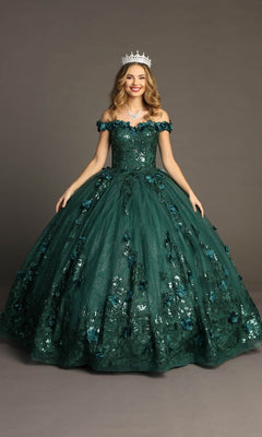 A young woman poses in front of a plain gray background, wearing the Quinceanera Dress CHF3069 By Chicas in green. The dress features an off-the-shoulder neckline with floral details, a delicate corset bodice, and a glitter tulle ballgown skirt. She completes her enchanting and elegant look with a sparkling tiara.