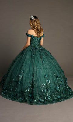 A woman is seen from behind, standing against a plain background and wearing the Quinceanera Dress CHF3069 by Chicas—a green, off-shoulder glitter tulle ballgown adorned with delicate floral details and paired with a crown.