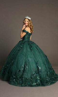 A woman wearing the Quinceanera Dress CHF3069 By Chicas—a green off-the-shoulder ballgown embellished with 3D floral appliques—stands against a gray background, smiling and crowned.