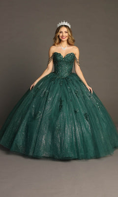 A woman wearing the Quinceanera Dress CHF3071 By Chicas in green, featuring a glitter-tulle ballgown skirt and a beaded bodice, stands against a plain gray background with a smile, her arms gently extended. She accessorizes with a silver tiara and necklace.