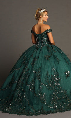 A woman wearing the Quinceanera Dress CHF3072 by Chicas—an elegant dark green, off-the-shoulder gown featuring glittering metallic embroidery and a flowing ballgown skirt—stands against a neutral background, crowned with a tiara.