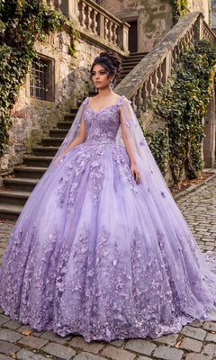 A woman stands on a stone path in front of stairs, wearing the Quinceanera Dress CHF3077 By Chicas, which features delicate floral details, butterfly appliques, and sheer cape sleeves.